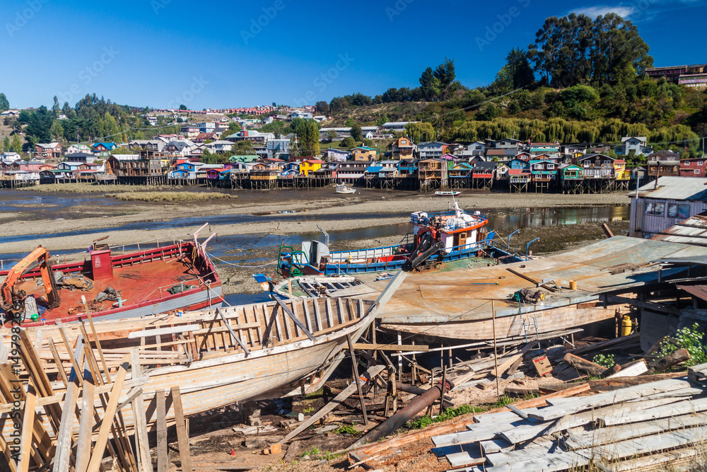 Fishing boats and palafitos (stilt houses) during low tide in Castro, Chiloe island, Chile