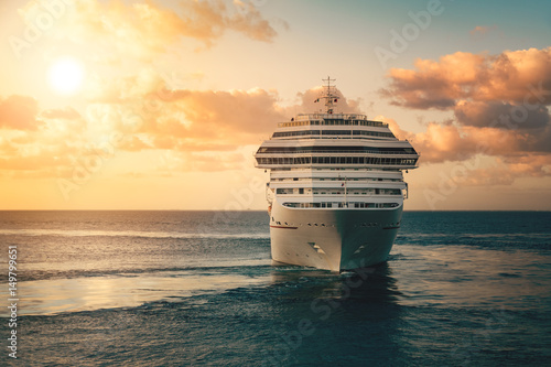 Fototapeta Luxury cruise ship leaving port at sunset