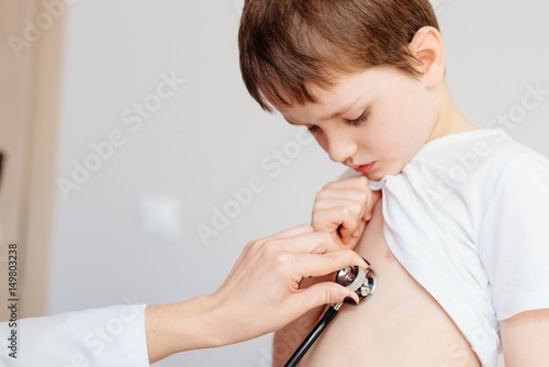 Small 7 year old boy is examined by a pediatrician