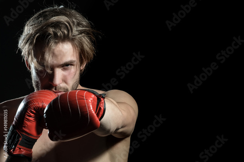 Professional boxer are fighthing isolated in black background. Portrait of boxer posing in studio in gloves. Boxing man ready to fight. Boxer with strong hands in boxing gloves © Tverdokhlib