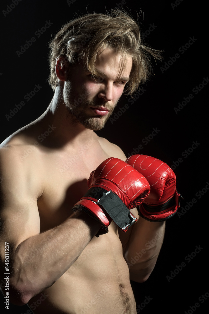 Attractive sexy boxer. Naked man in boxing red gloves in training. Beautiful boxer with fashionable hair and beard. Model for advertising sports, coach or gym