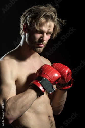 Attractive sexy boxer. Naked man in boxing red gloves in training. Beautiful boxer with fashionable hair and beard. Model for advertising sports, coach or gym © Tverdokhlib