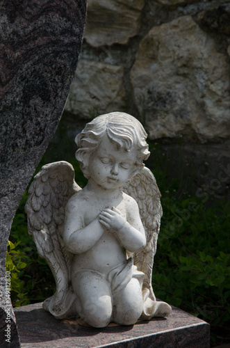 knieende engelsfigur an einem grabstein