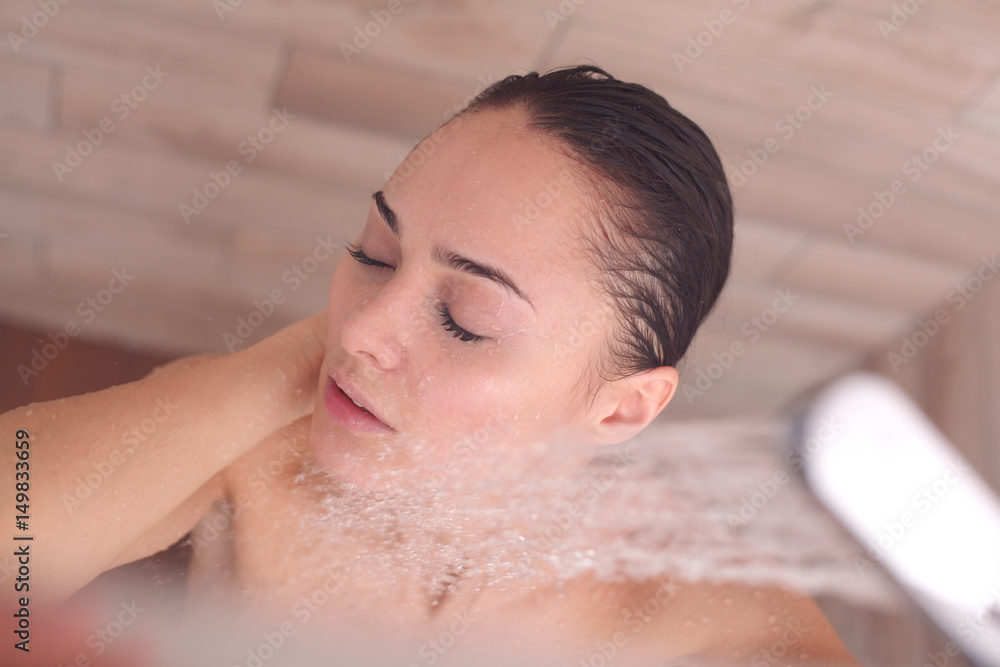 Naklejka premium Young beautyful woman under shower in bathroom