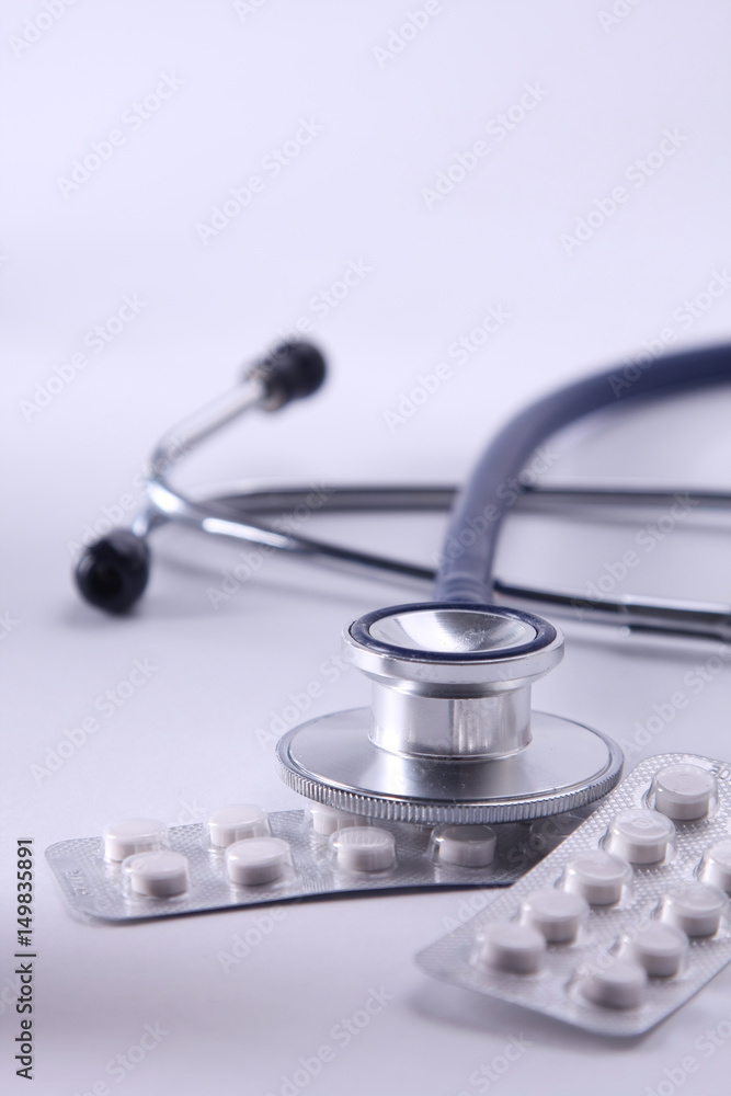 Stethoscope, pills on light background. medicine concept Stethoscope, pills on light background. medicine concept