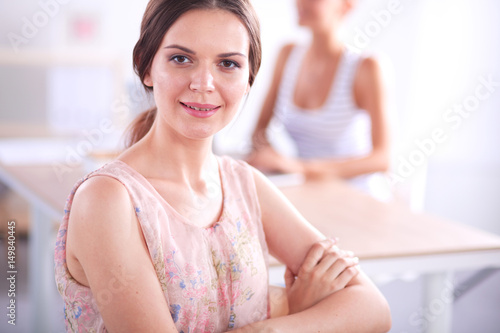 Attractive businesswoman sitting on desk in the office Free Download Attractive businesswoman sitting on desk in the office - GFXLoad