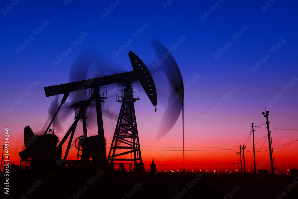Pumping unit in the work, under the sunset of oilfield Pumping unit in the work, under the sunset of oilfield