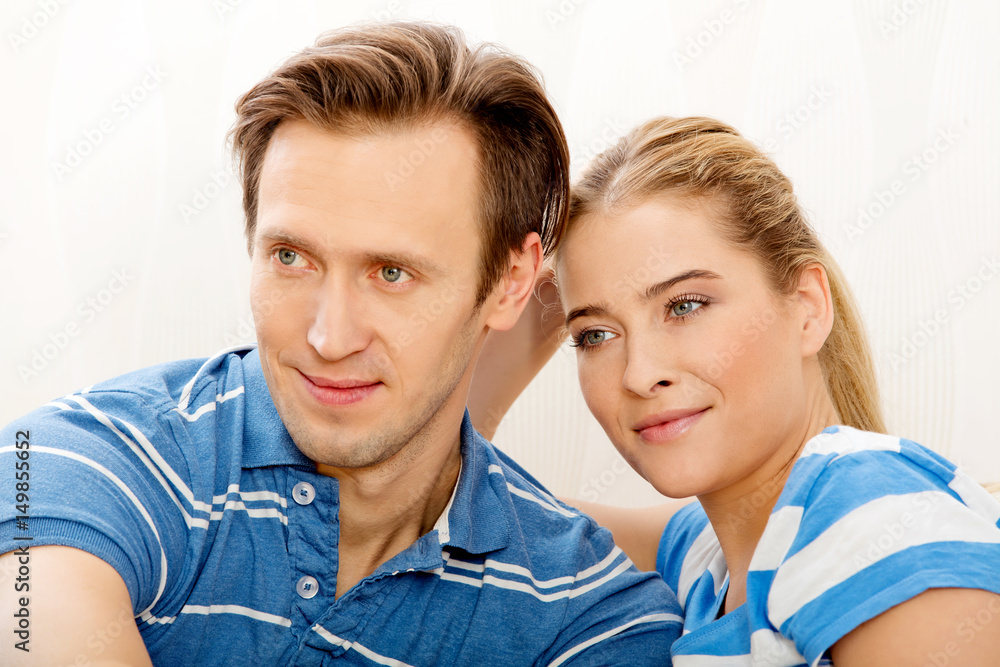 Smiling loving couple sitting on couch Smiling loving couple sitting on couch