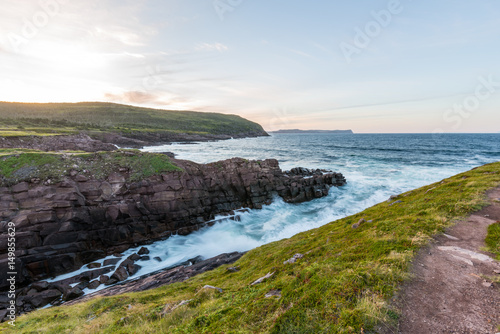 Waves crashing on the shores of Newfoundland in the setting sun