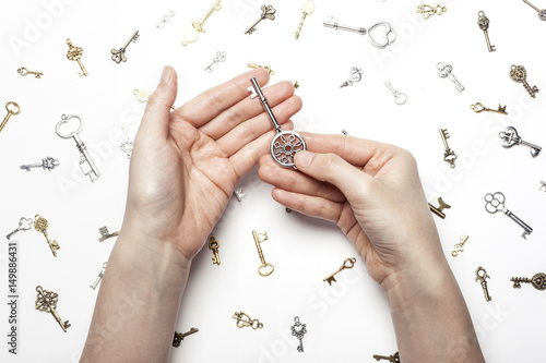 woman hand hold a vintage key isolated white. photo