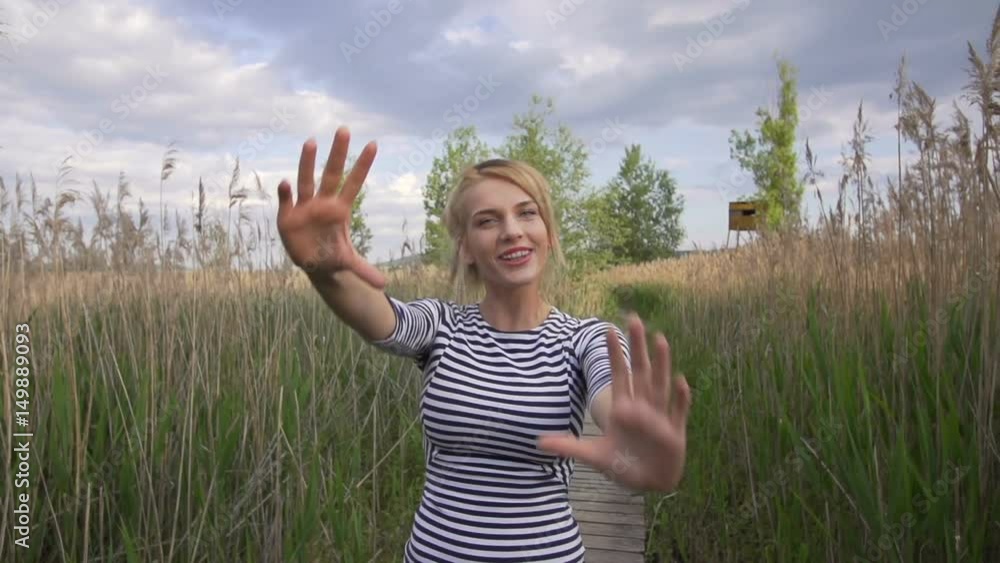 beautiful blond girl in nature - bulrush. dancing and hang naughty in front of camera beautiful blond girl in nature - bulrush. dancing and hang naughty in front of camera