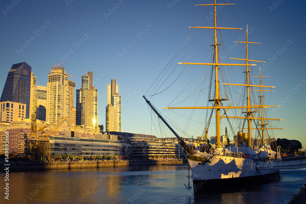 Argentina, Buenos Aires, South America - Frigate Sarmiento with buildings in the background at sunset in Puerto Madero. Argentina, Buenos Aires, South America - Frigate Sarmiento with buildings in the background at sunset in Puerto Madero.