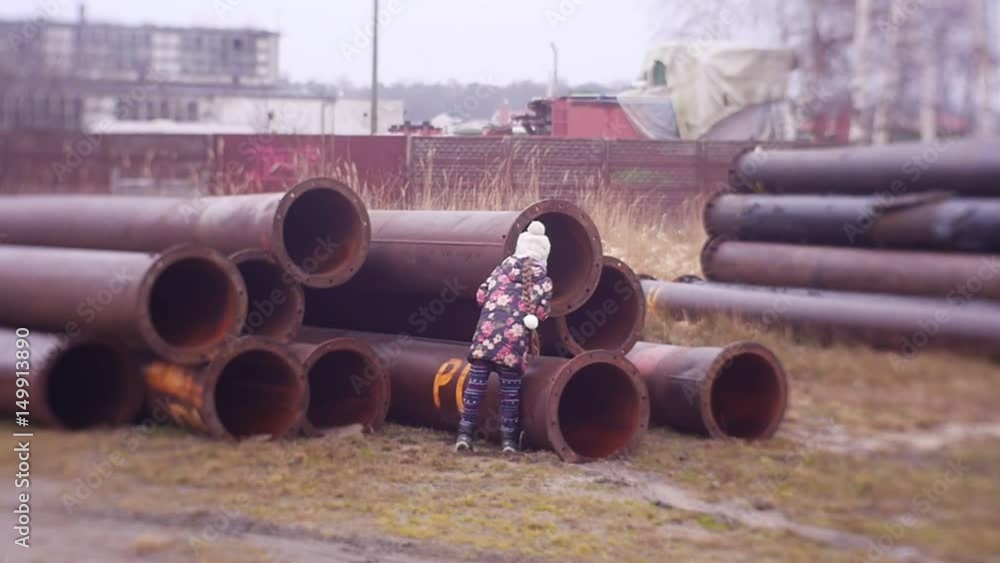 a Girl, a Child at a Construction Site Looks in a Large Diameter Pipe, Dangerous Games on an Abandoned Building, Abandoned Construction a Girl, a Child at a Construction Site Looks in a Large Diameter Pipe, Dangerous Games on an Abandoned Building, Abandoned Construction