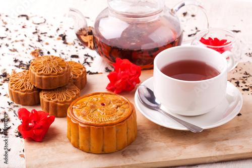 Chinese mid autumn festival foods. Traditional moon cakes on table setting with teacup.