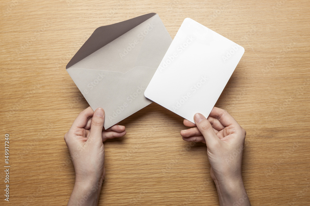 Obraz premium woman hand hold a letter and envelope on the wood table.