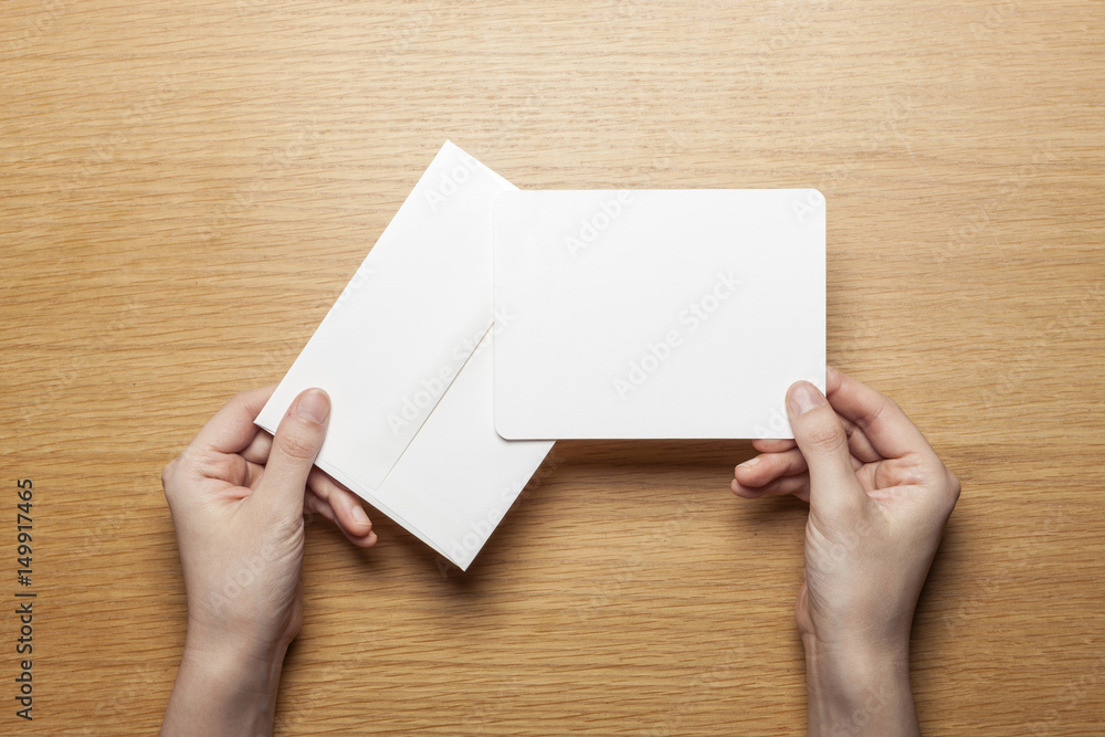 Obraz premium woman hand hold a letter and envelope on the wood table.