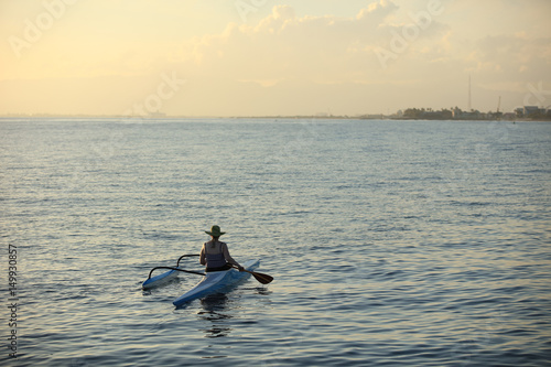 Wallpaper Mural Woman in wide heat floating on canoe on ocean water at sunset time Torontodigital.ca