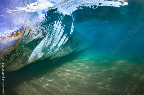Fototapeta Naklejka Na Ścianę i Meble -  Underwater view of sea water surface in shape of rolling wave with sandy bottom