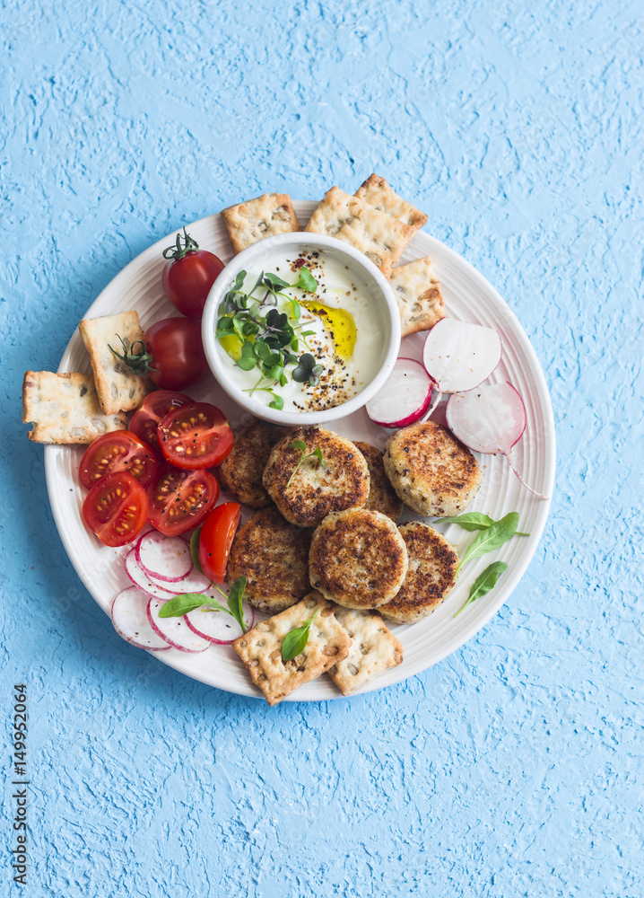 Snack plate. Cauliflower meatballs, tomatoes, radish, gluten-free, cracker and sauce. Healthy vegetarian snack. Top view Snack plate. Cauliflower meatballs, tomatoes, radish, gluten-free, cracker and sauce. Healthy vegetarian snack. Top view