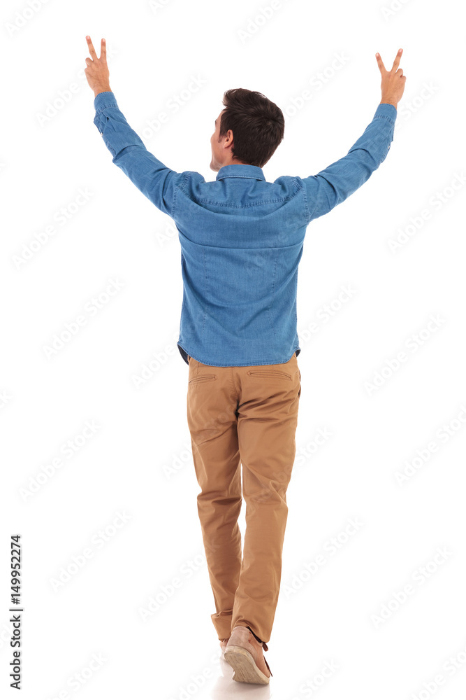 back of a man walking with hands up making victory back of a man walking with hands up making victory