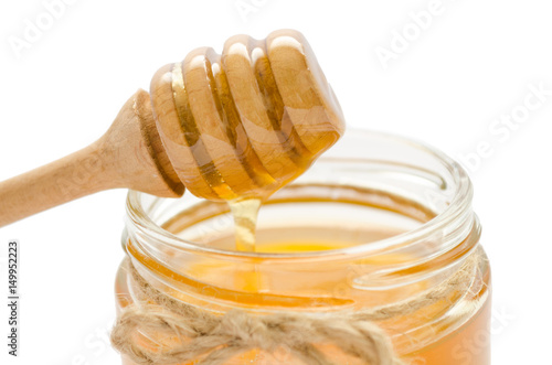 jar with honey and honey spoon on it.