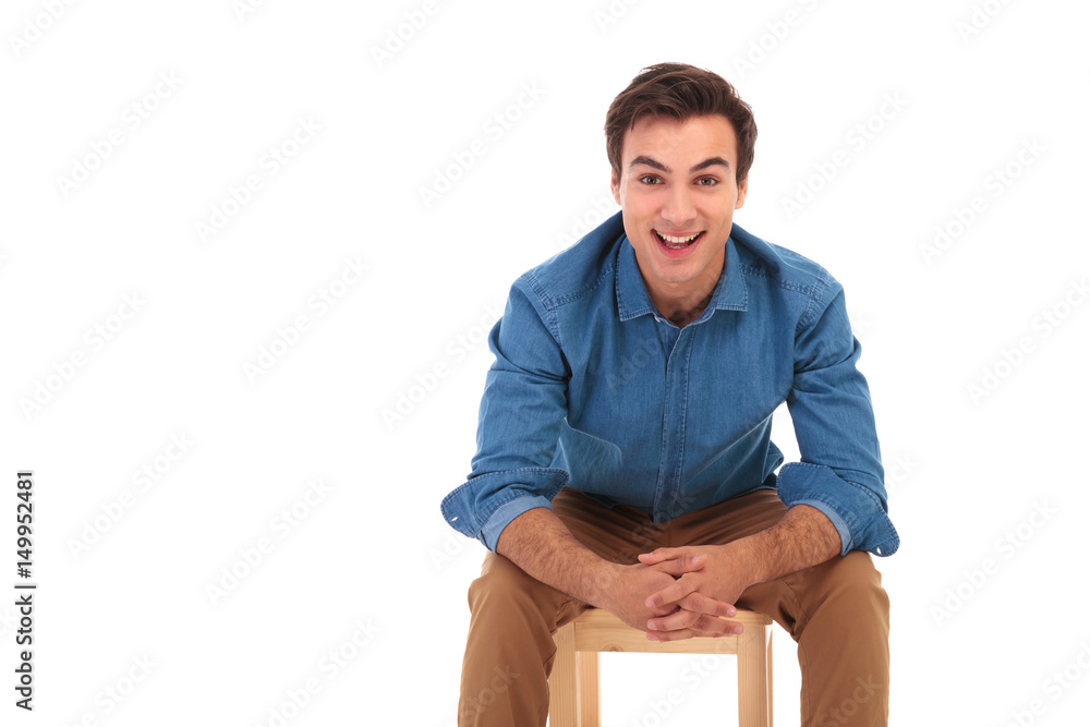 smiling casual man resting elbows on knees while sitting smiling casual man resting elbows on knees while sitting