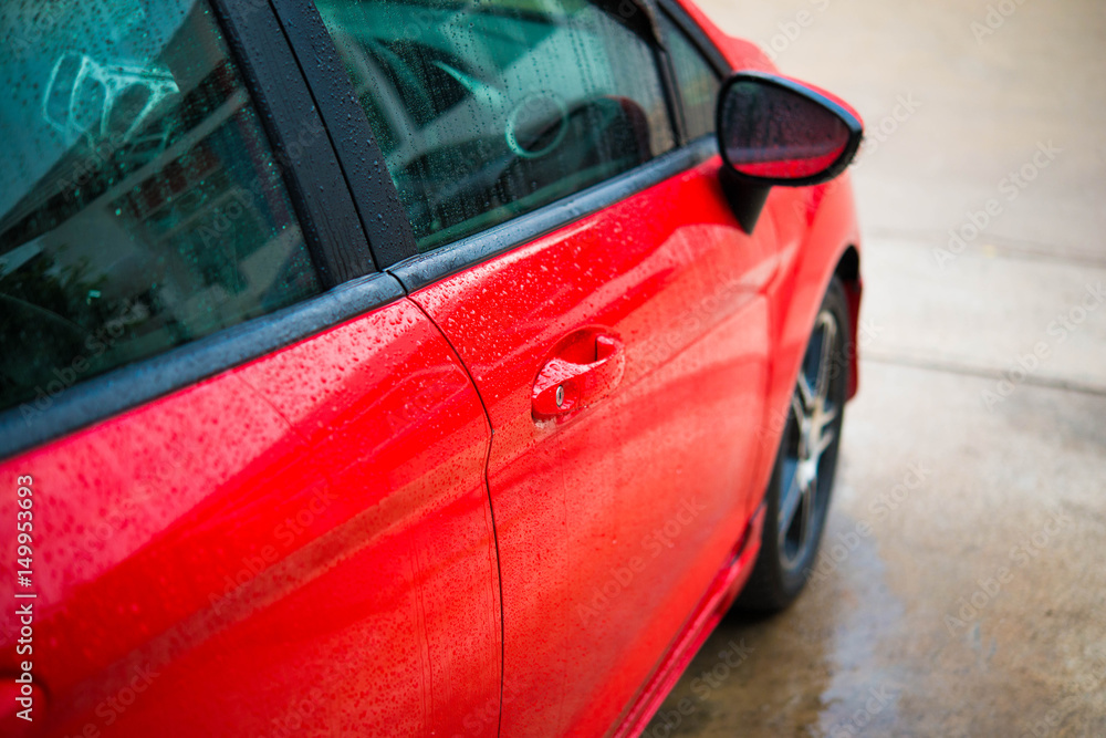 Worker cleaning red car