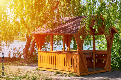 Papier peint gazebo for family entertainment and is made of wood, stands on the shore of the
