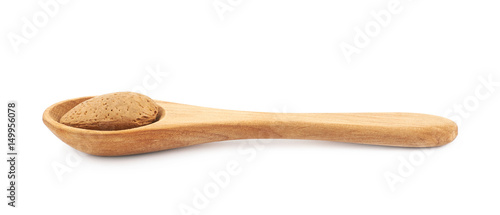 Almond nut in a wooden spoon isolated
