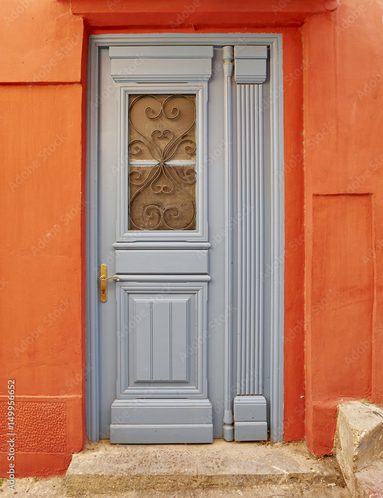 grey door on vibrant orange house wall