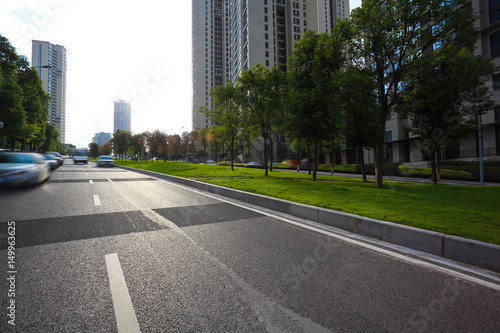 Empty road surface floor with City streetscape buildings © Aania