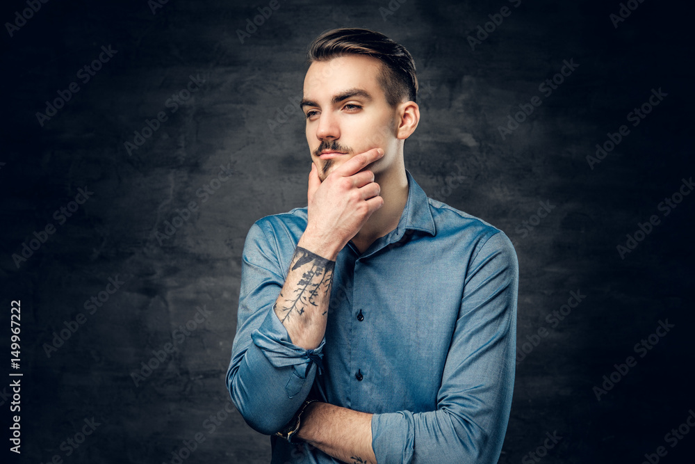 Thoughtful male with tattooed arm. Thoughtful male with tattooed arm.