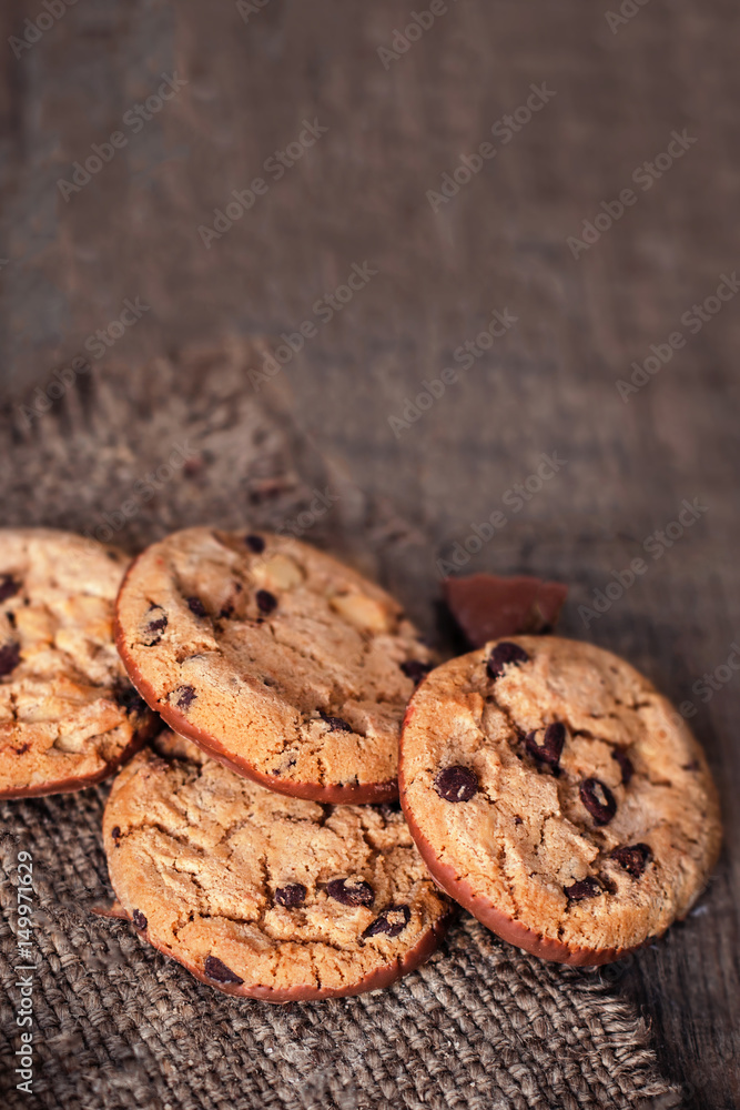 Chocolate cookies on dark napkin on wooden table. Chocolate chip cookies on brown coffee color cloth, macro, top view Chocolate cookies on dark napkin on wooden table. Chocolate chip cookies on brown coffee color cloth, macro, top view