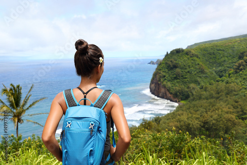 Hawaii travel nature hiker girl hiking in Pololu valley enjoying lookout view of mountains. Big island destination, woman tourist in Hawaii, USA. photo