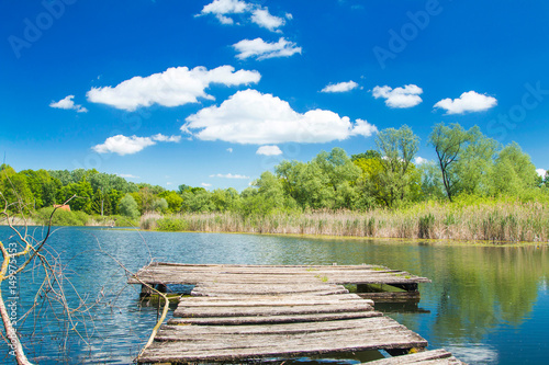 Beautiful landscape scenery – old wooden dock on lake in nature park Lonjsko polje, Croatia