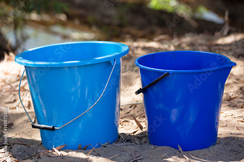 Blue plastic pails on sand