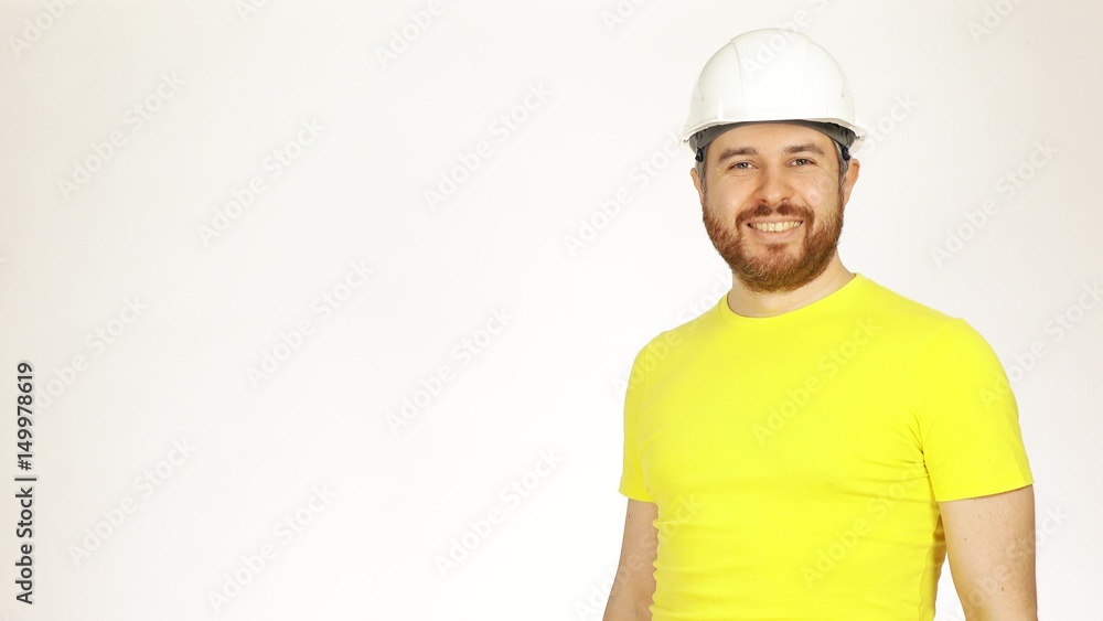 Portrait of handsome smiling construction engineer or architect in yellow tshirt and hard hat against white background