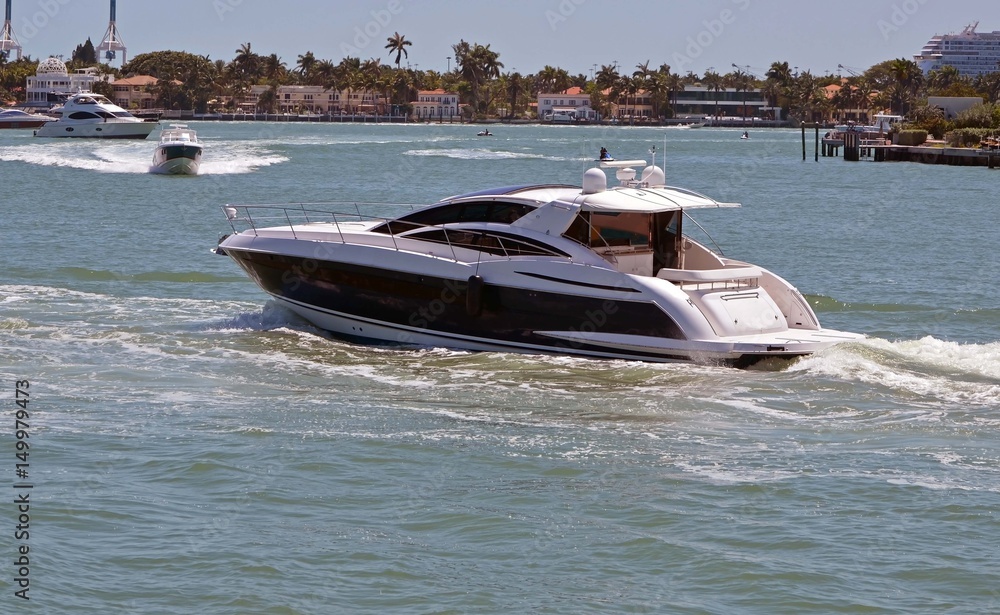Obraz premium Upscale cabin cruiser cruising on the florida intra-coastal waterway near Miami Beach on a Saturday afternoon.