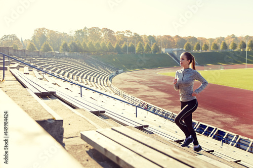 happy young woman running upstairs on stadium