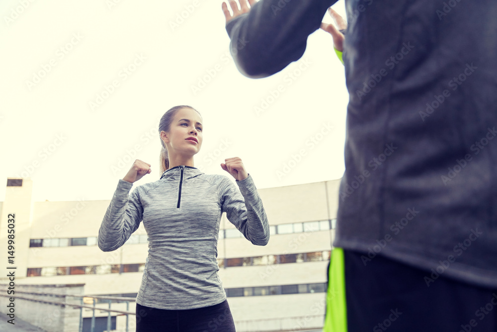 Naklejka premium woman with trainer working out self defense strike