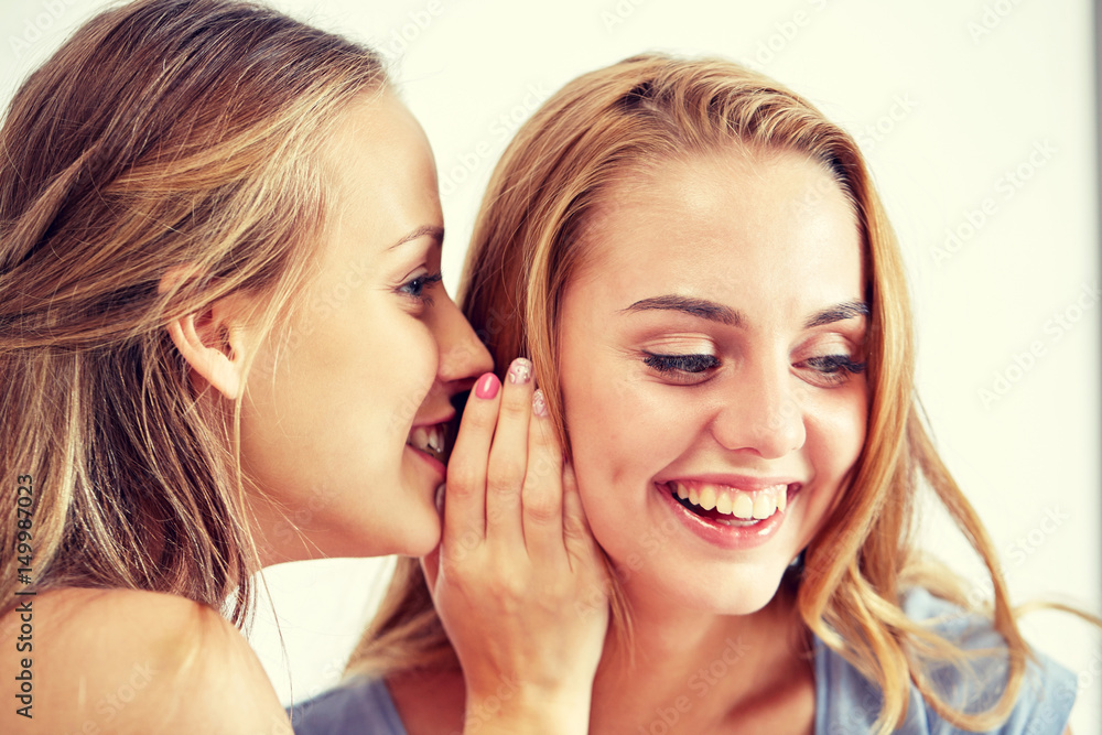 happy young women whispering gossip at home happy young women whispering gossip at home