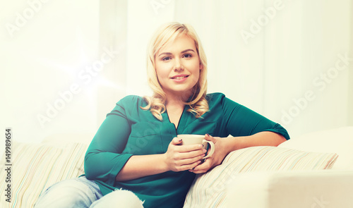 happy woman  with cup of tea or coffee at home © Syda Productions