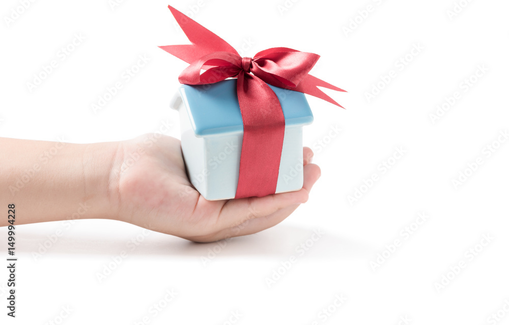 house piggy bank with red ribbon in little hand house piggy bank with red ribbon in little hand