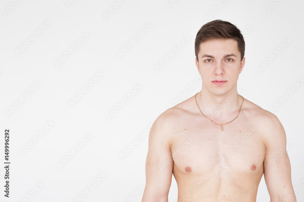 Fototapeta premium studio portrait young sexy men bodybuilder athlete, with a bare torso, Standing in full length on a white background in underwear underwear, Belt is photographed, gold chain with a cross on the neck
