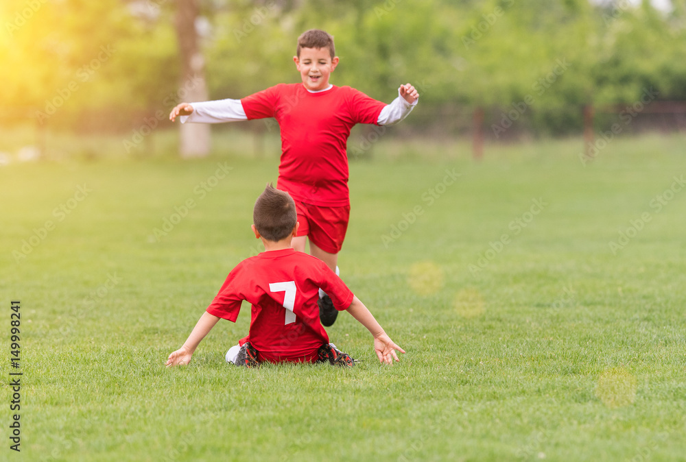 Obraz premium Kids soccer football - children players match on soccer field