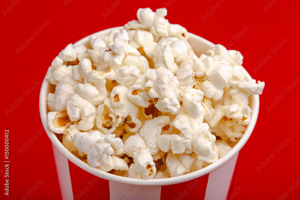 Popcorn in red and white cardboard box. Popcorn border isolated on white. Film. Fast food. Corn Popcorn in red and white cardboard box. Popcorn border isolated on white. Film. Fast food. Corn