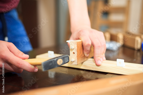 Man hands constructing a chairs with some tools, woodwork