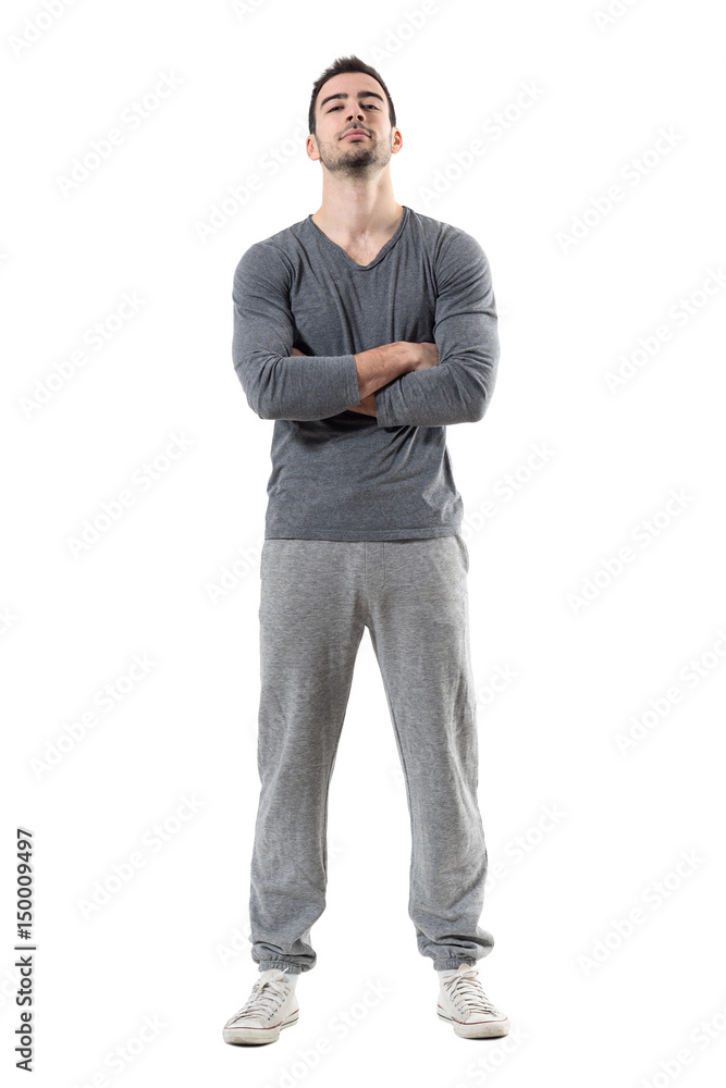 Fototapeta premium Tough proud serious athlete with crossed arms and head tilted back. Full body length portrait isolated on white studio background. 