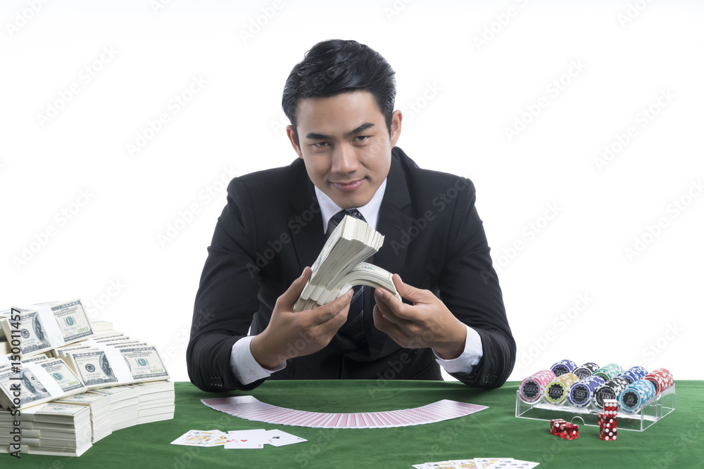 Φωτογραφία The handsome man holding piles of dollars in hand at casino desk