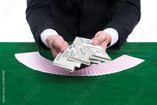 Wallpaper Mural The hands holding pile of banknote and spread cards on green casino table Torontodigital.ca